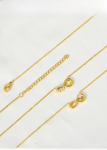 Macro shot of gold titanium steel infinity pendant necklace with sparkling zircon pavé