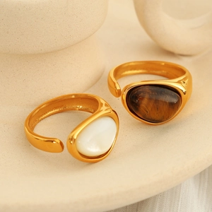 French vintage adjustable gold rings with white and brown tiger eye stones on a ceramic tray