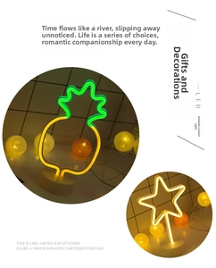 Detail of LED neon pineapple and star night lights with round bases and warm glow
