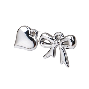 Silver heart and bow metallic pendants for DIY jewelry making on white background