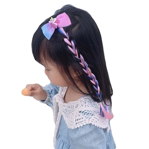 Detail of pink bow hair clip with unicorn and gradient colored braided hairpiece