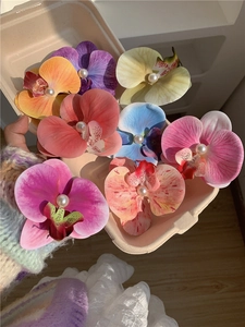 Macro detail of multi-colored phalaenopsis orchid hair clips with center pearl accents