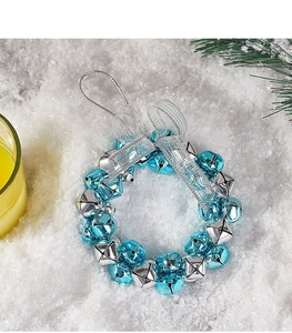Close-up of blue and silver Christmas bell wreath with a silver mesh ribbon bow on snow