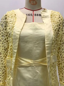 Détail d'un ensemble deux pièces jaune avec cardigan en dentelle et jupe en satin