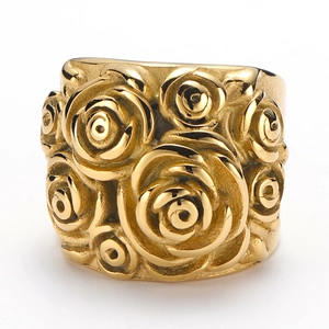 Close-up of golden wide ring with detailed embossed rose floral patterns and metallic finish