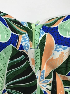 Detail of colorful tropical leaf print fabric with light green invisible zipper