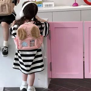 Pink puppy ear kids backpack with star detail shown on child model for kindergarten