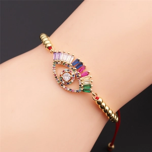 Adjustable gold evil eye bracelet with colorful zircons and red rope on woman wrist