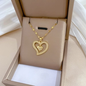 Luxurious gold double heart necklace with sparkling zircon pavé in a beige jewelry box