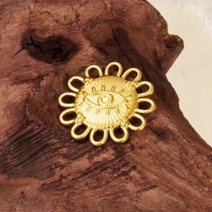 Gold plated stainless steel evil eye sunflower pendant on a rustic wood background
