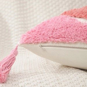 Detail view of pink fringe tassels and hidden zipper on geometric tufted pillow case