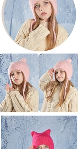 Detail of knit texture and cat ears on warm winter hats for children in pink and red