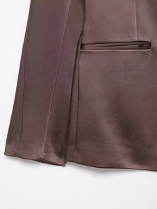 Detailed view of the smooth satin fabric and pocket flap on the chocolate blazer