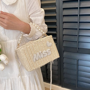Beige woven straw handbag with pearl handle and MISS rhinestone design for summer vacation