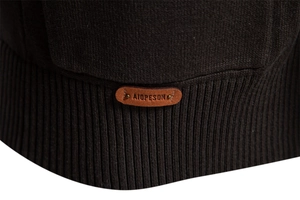 Detail of ribbed hem on dark brown knit sweater with premium leather logo patch