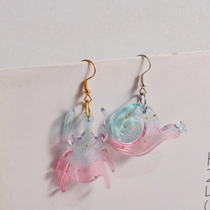 Asymmetric beetle and snail resin earrings with blue-pink gradient and gold glitter