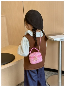 Girl wearing a pink sequin quilted crossbody bag with metal chain strap detail