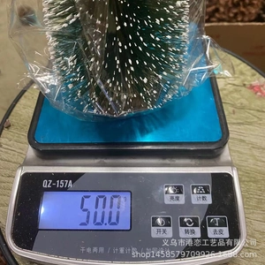 Detailed scale measurement showing the 50g weight of the snowy pine mini Christmas tree