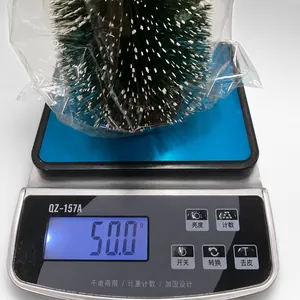 Detaillierte Waagemessung zeigt das 50g Gewicht des verschneiten Mini-Weihnachtsbaums