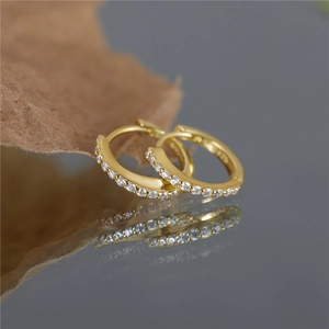 Macro detail of S925 gold plated hoop earrings with cross octagonal star zircon inlay