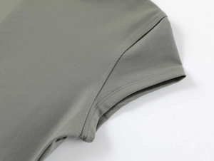 Macro shot of double-needle stitching on olive green gym shirt sleeves and shoulder seams