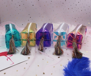 Macro detail of holographic pencil cases with colorful tassels and shimmering laser finish