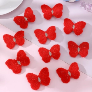 Detail shot of red butterfly felt patches with silver stitching on a pink background