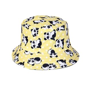 Detailed view of yellow bucket hat featuring cartoon panda and white polka dot patterns