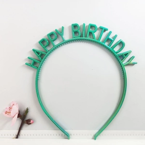 Detail view of a green plastic Happy Birthday headband with letters and inner hair comb teeth