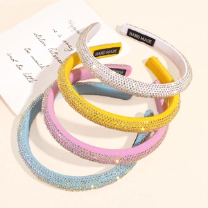 Close-up of four colorful rhinestone headbands with handmade labels and stylish design