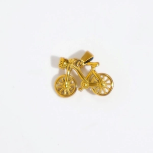 Detailed close-up of a gold bicycle pendant showing intricate metal frame and wheels