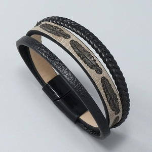 Detail of woven leather bracelet with feather charm and black magnetic clasp closure