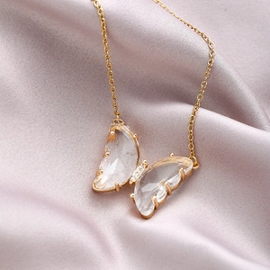 Elegant gold butterfly crystal necklace for women on light purple silk background