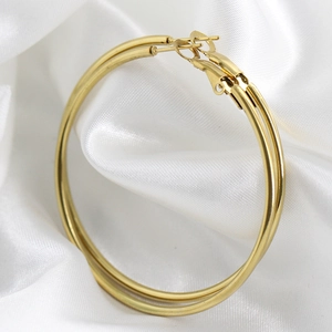 Polished 18K gold plated large hoop earrings on elegant white silk fabric background