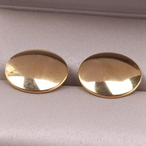 Macro view of minimalist 304 stainless steel gold stud earrings on a velvet jewelry box