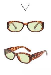 Detail of vintage narrow tortoise frame sunglasses with light green lenses and metal hinges