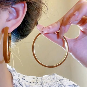 Vintage brown flocked hoop earrings with gold metal interior worn by a female model
