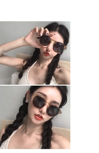Close-up of vintage tea-colored round sunglasses with amber frames worn by a model