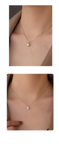 Close-up of a gold S925 silver necklace with a sparkling round clear zircon pendant