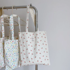 Close-up of floral print cotton tote bag with detailed stitching and brand label