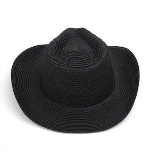 Dettaglio del cappello da cowboy in paglia nera con trama circolare e corona incavata