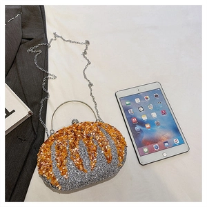 Detail of silver pumpkin evening clutch with orange stone accents and metal handle