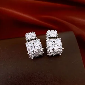 Elegante zilveren oorbellen met sprankelend zirkonia bloemmotief op donkere achtergrond