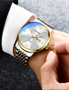 Close-up of luxury quartz watch with dual calendar display and silver sunray dial