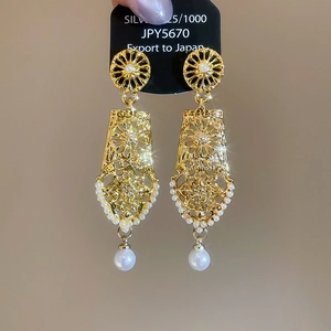Macro shot of retro geometric hollow earrings featuring 925 silver and drop pearl details
