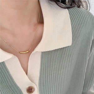 Close-up of a minimalist gold 925 sterling silver teardrop necklace on model collarbone