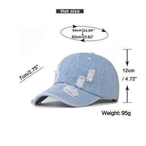 Detail view of washed denim baseball cap with distressed holes and silver rings decoration