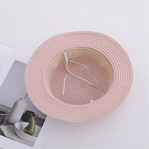 Detailed view of pink straw sun hat showing interior sweatband and adjustable drawstring