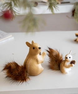 Detailed close-up of fluffy squirrel ornaments with soft fur tails and pine cones