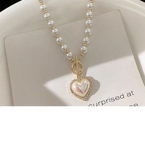 Detail view of heart pearl necklace with gold OT clasp and shimmering crystal border